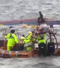 Coast guard members conduct a search and rescue operation near the capsized fishing boat Dolphin in waters near Chuja Island off the country's southern coast Sunday. The Jeju coast guard released this footage.  (Yonhap)