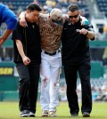 Pittsburgh Pirates' Kang Jung-ho, center, is helped off the field by a team trainer, right, and his interpreter after injuring his left leg turning a double play in the first inning of a baseball game against the Chicago Cubs in Pittsburgh, Thursday, Sept. 17, 2015. Kang left the game. (AP Photo/Gene J. Puskar)