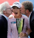 Lydia Ko of New Zealand, center, is kissed by Danone's CEO Franck Riboud, left, and Jacques Bungert, the vice chairman of the Evian championship after winning the Evian Championship women's golf tournament in Evian, eastern France, Sunday, Sept. 13, 2015. (AP Photo/Laurent Cipriani)