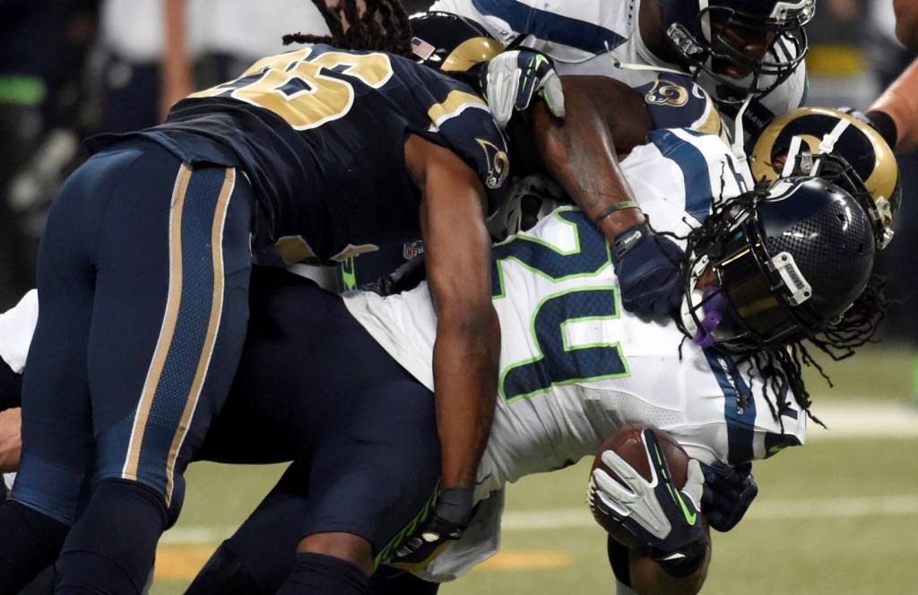 Seattle Seahawks running back Marshawn Lynch, right, struggles for yardage before being brought down by St. Louis Rams strong safety Mark Barron, left, during the first quarter of an NFL football game Sunday, Sept. 13, 2015, in St. Louis. (AP Photo/L.G. Patterson)