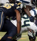 Seattle Seahawks running back Marshawn Lynch, right, struggles for yardage before being brought down by St. Louis Rams strong safety Mark Barron, left, during the first quarter of an NFL football game Sunday, Sept. 13, 2015, in St. Louis. (AP Photo/L.G. Patterson)