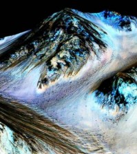 This undated photo provided by NASA and taken by an instrument aboard the agency's Mars Reconnaissance Orbiter shows dark, narrow, 100 meter-long streaks on the surface of Mars that scientists believe were caused by flowing streams of salty water. Researchers said Monday, Sept. 28, 2015, that the latest observations strongly support the longtime theory that salt water in liquid form flows down certain Martian slopes each summer. (NASA/JPL/University of Arizona via AP)