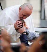 Pope Francis passes the crowd and kisses a baby in his pope mobile in Philadelphia on Saturday, Sept. 26, 2015. The pope spoke at Independence Hall on his first visit to the United States. (Jim Bourg/Pool Photo via AP)
