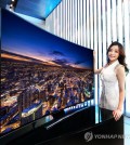 A model stands with a Samsung UHD television.(Yonhap)