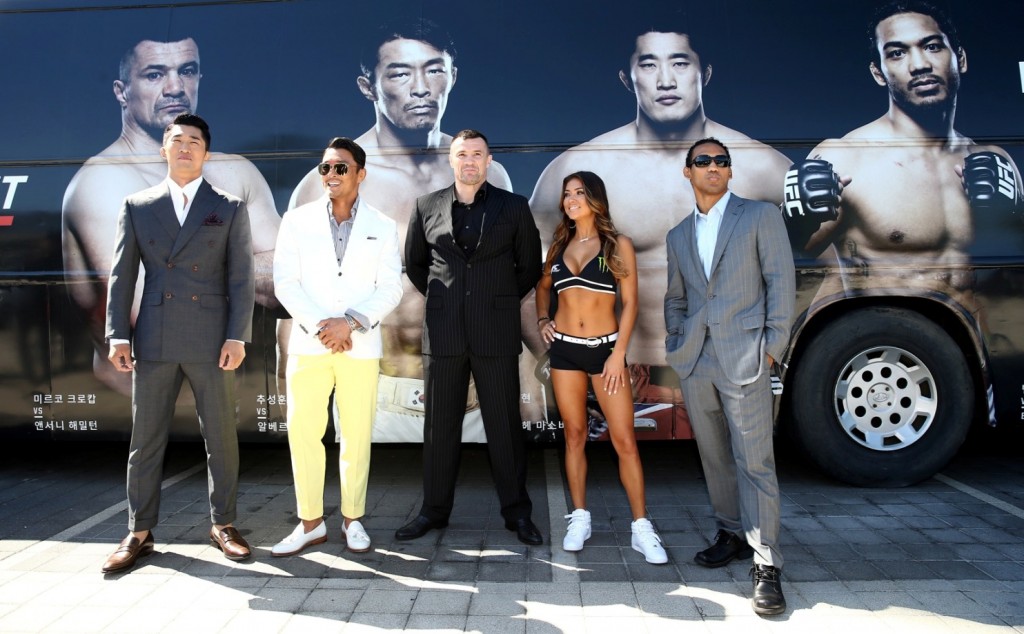 From left, Ultimate Fighting Championship fighters Kim Dong-hyun, Yoshihiro Akiyama, Mirko Filipovic, Benson Henderson pose for photos with a ring girl after the press conference in Seoul. (Newsis)