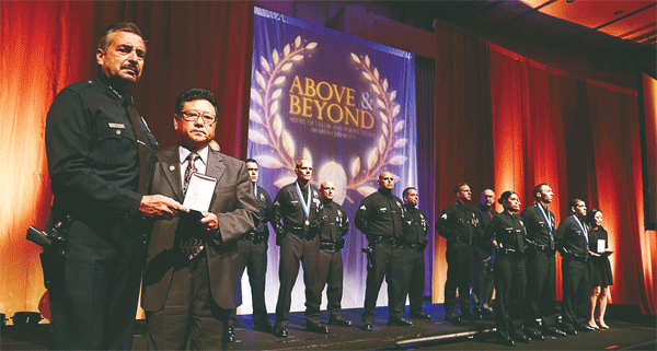 Lee Heung-jae, right, receives a Purple Heart from LAPD Chief Charlie Beck for the services of his son, Nicholas Lee, who was killed last year during patrol. (Choi Kyung-geun/Korea Times)