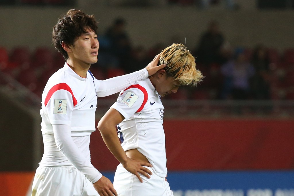 Lee Seung-woo, right, and Lee Sang-min walk off the field after a disappointing loss to Belgium. (Yonhap)