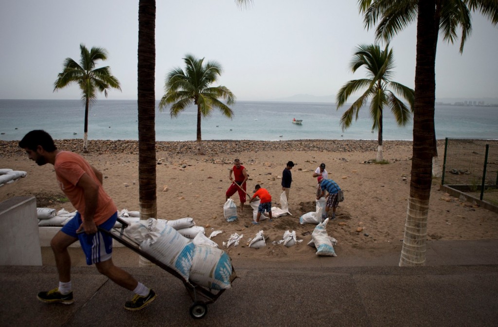 Residents prepare for the arrival of Hurricane Patricia filling sand bags to protect beachfront businesses, in Puerto Vallarta, Mexico, Friday, Oct. 23, 2015. Patricia barreled toward southwestern Mexico Friday as a monster Category 5 storm, the strongest ever in the Western Hemisphere. Locals and tourists were either hunkering down or trying to make last-minute escapes ahead of what forecasters called a "potentially catastrophic landfall" later in the day. (AP Photo/Rebecca Blackwell)