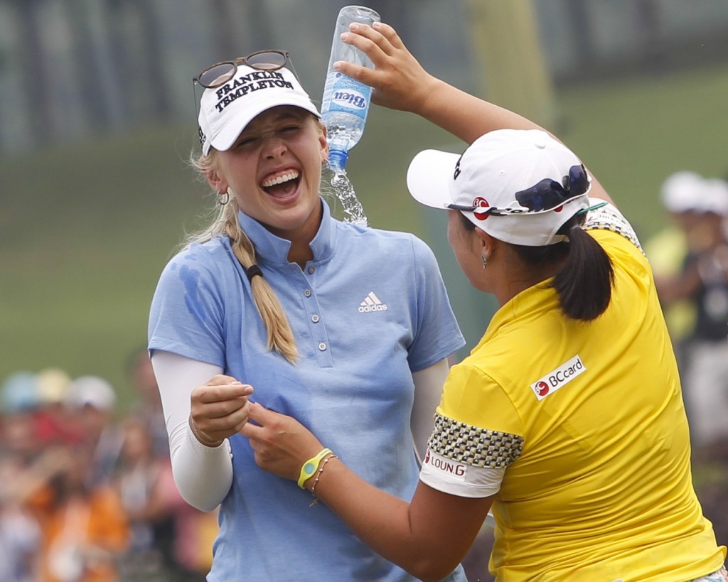 Jessica Korda, left, of the United States is poured water by fellow golfer Ha Na Jang of South Korea after winning the LPGA Malaysia golf tournament at Kuala Lumpur Golf and Country Club in Kuala Lumpur, Malaysia, Sunday, Oct. 11, 2015.(AP Photo/Joshua Paul)