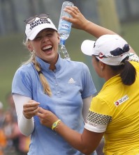 Jessica Korda, left, of the United States is poured water by fellow golfer Ha Na Jang of South Korea after winning the LPGA Malaysia golf tournament at Kuala Lumpur Golf and Country Club in Kuala Lumpur, Malaysia, Sunday, Oct. 11, 2015.(AP Photo/Joshua Paul)