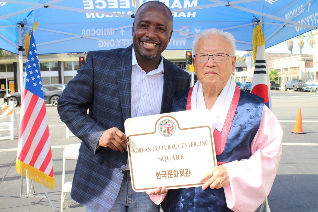 Lee Gwang-deok, president of the Korean Cultural Center, and Los Angeles City Councilman Marqueece Harris-Dawson hold up a sign designating the Korean Cultural Center Inc. Square. (Bae Goon-chan/Korea Times)