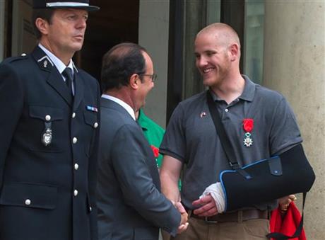 FILE - In this Aug. 24, 2015 file photo, French President Francois Hollande shakes hands with U.S. Airman Spencer Stone outside the Elysee Palace in Paris after Hollande awarded Stone and two friends with the French Legion of Honor for subduing a gunman on a Paris-bound train three days earlier. Stone is in stable condition Thursday, Oct. 8, 2015, after being stabbed in Sacramento, Calif., according to an Air Force spokesman. (AP Photo/Kamil Zihnioglu, File)