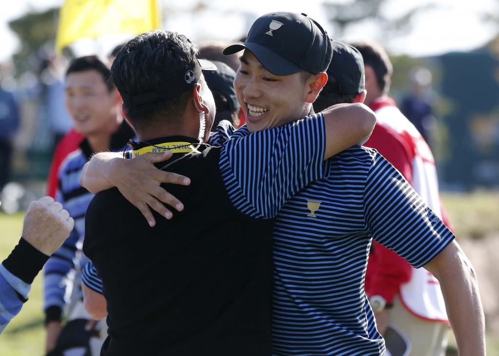 International team player Bae Sang-moon, right, of South Korea is embraced by compatriot and team vice captain K.J.Choi after winning their four ball match at the Presidents Cup golf tournament at the Jack Nicklaus Golf Club Korea, in Incheon, South Korea, Friday, Oct. 9, 2015.(AP Photo/Lee Jin-man)