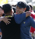 International team player Bae Sang-moon, right, of South Korea is embraced by compatriot and team vice captain K.J.Choi after winning their four ball match at the Presidents Cup golf tournament at the Jack Nicklaus Golf Club Korea, in Incheon, South Korea, Friday, Oct. 9, 2015.(AP Photo/Lee Jin-man)
