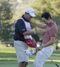 Bae Sang-Moon of South Korea, right, is greeted by his caddy and spray from sparkling wine on the 18th green of the Silverado Resort North Course after winning the Frys.com PGA Tour golf tournament Sunday, Oct. 12, 2014, in Napa, Calif. Bae Sang-Moon won the tournament after shooting a 1-over-par 73 to finish at total 15-under-par. (AP Photo/Eric Risberg)