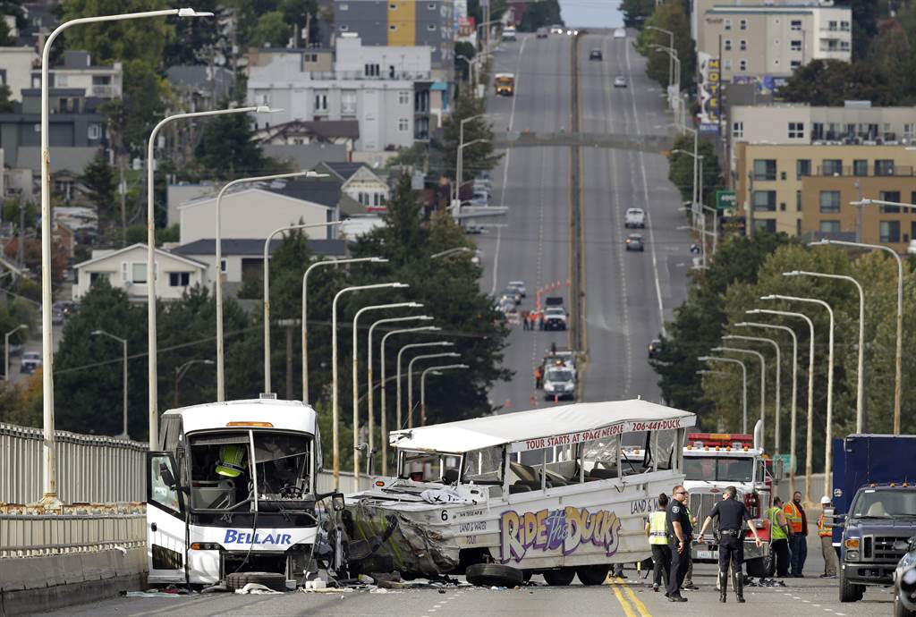A tour bus, right, and a chartered passenger bus, left, remain on the Aurora Ave. Bridge following a fatal crash earlier in the day, Thursday, Sept. 24, 2015 in Seattle. (AP Photo/Ted S. Warren)