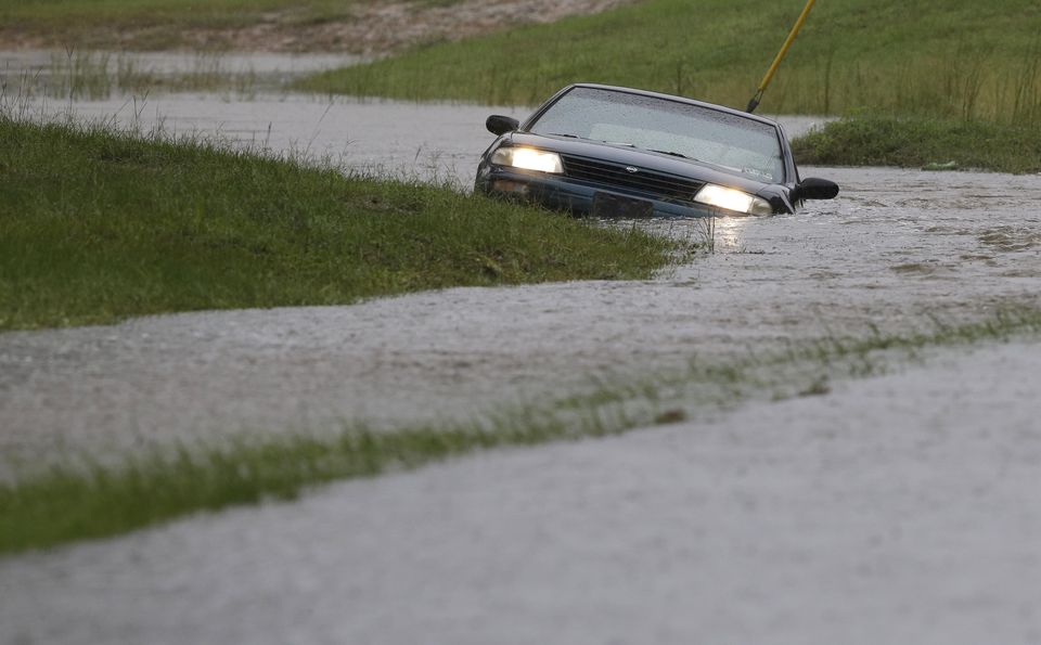 A car is submerged in floodwaters in Florence, S.C., Sunday, Oct. 4, 2015 after steady rain left many roads impassable, while flooding continues in many parts of the state. (AP Photo/Gerry Broome)