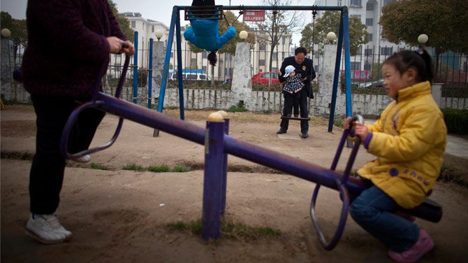 In this April 5, 2010 file hoto, Chinese grandparents and grandchildren play in a park in Dafeng, in east China's Jiangsu province. China's ruling Communist Party announced Thursday, Oct. 29, 2015, that it will abolish the country's decades-old one-child policy and allow all couples to have two children, removing remaining restrictions that limited many urban couples to only one, the official Xinhua News Agency said. (AP Photo/Alexander F. Yuan, file)