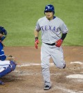 Texas Rangers' Choo Shin-soo, right, crosses home plate in front of Toronto Blue Jays catcher Russell Martin following a solo home run during the third inning in Game 5 of baseball's American League Division Series, Wednesday, Oct. 14, 2015 in Toronto. (Darren Calabrese/The Canadian Press via AP)