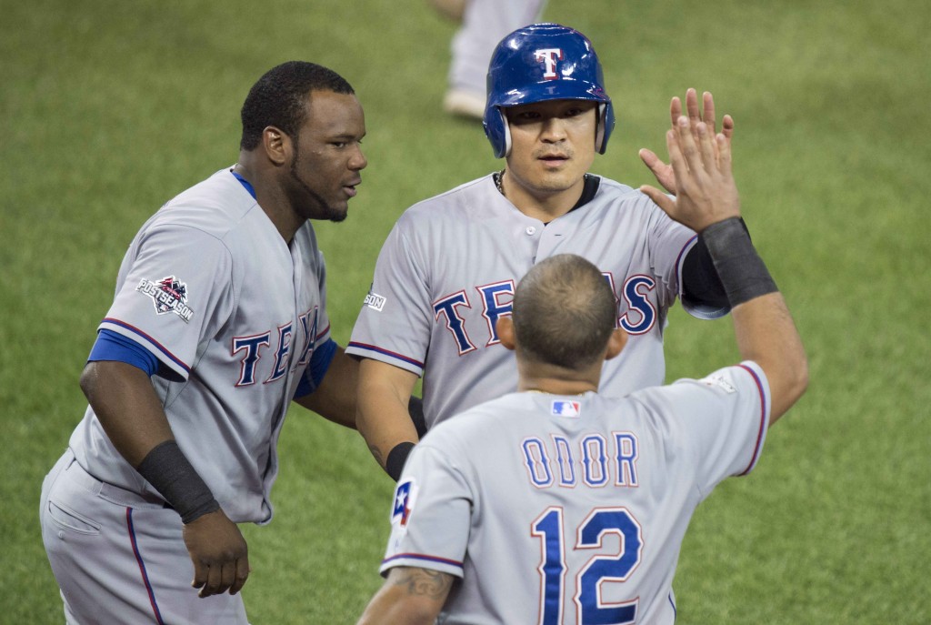 Texas Rangers, from left to right, Hanser Alberto, Choo Shin-soo, and Rougned Odor celebrate Choo scoring during the first inning in Game 2 of baseballs American League Division Series in Toronto on Friday, Oct. 9, 2015. (Darren Calabrese/The Canadian Press via AP)