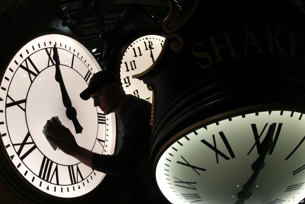 Dave LeMote wipes down a post clock at Electric Time Company, Inc. in Medfield, Mass. Most Americans will set their clocks 60 minutes back before heading to bed Saturday night, but daylight saving time officially ends Sunday at 2 a.m. local time. (AP Photo/Elise Amendola)