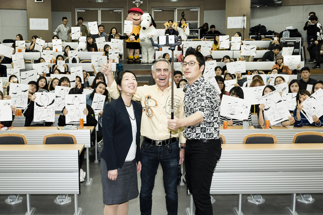 Steve Martino, center, director of "The Peanuts Movie," Sung Ji-yeon, left, lightening supervisor at Blue Sky Studios, and cartoonist Kim Poong take a selfie during a discussion about the upcoming animated feature based on Charles Schulz's comic strip "Peanuts" at Ewha Womans University in Seoul, on Oct. 15. (Courtesy of 20th Century Fox Korea)