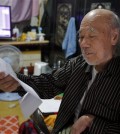In this Oct. 15, 2015 photo, South Korean Kim Wu-jong, 87, who will travel to North Korea to meet his younger sister, looks at a document from the Red Cross during the interview at his home in Seoul, South Korea. Kim and about 640 other South Koreans will meet their North Korean relatives at the authoritarian country’s scenic Diamond Mountain resort in a reunion program that begins Tuesday, Oct. 20. Tens of thousands of people on both sides of the Demilitarized Zone desperately seek such reunions, but the two countries have pulled off relatively few of them. (AP Photo/Lee Jin-man)