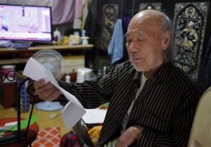 In this Oct. 15, 2015 photo, South Korean Kim Wu-jong, 87, who will travel to North Korea to meet his younger sister, looks at a document from the Red Cross during the interview at his home in Seoul, South Korea. Kim and about 640 other South Koreans will meet their North Korean relatives at the authoritarian country’s scenic Diamond Mountain resort in a reunion program that begins Tuesday, Oct. 20. Tens of thousands of people on both sides of the Demilitarized Zone desperately seek such reunions, but the two countries have pulled off relatively few of them. (AP Photo/Lee Jin-man)