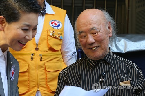 South Korean resident Kim Woo-jong (R), 87, learns he was included in the final list of family members separated by the 1950-53 Korean War to join the upcoming reunions, as he meets with Kim Sung-joo, South Korea`s Red Cross chief, at his house in Seoul on Oct. 8, 2015. The relief group handed over a list of 90 South Koreans hoping to meet their relatives living in North Korea while the North delivered a list of 97 North Korean family members to the South. (Yonhap)