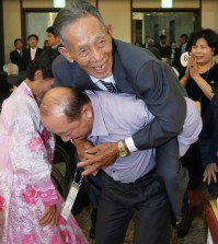 North Korean family member Sin Kyong Muk, 82, is carried by his South Korean niece's husband Jeong Wu-il, 55, on his back during the Separated Family Reunion Meeting at Diamond Mountain resort in North Korea, Wednesday, Oct. 21, 2015. Hundreds of elderly Koreans from divided North and South began three days of reunions Tuesday with loved ones many have had no contact with since the war between the countries more than 60 years ago. (Kim Do-hoon/Yonhap via AP)