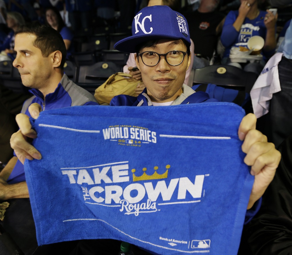Kansas City Royals fan Lee Sung-woo, from South Korea, shows off a World Series towel before Game 1 of baseball's World Series between the Kansas City Royals and the San Francisco Giants Tuesday, Oct. 21, 2014, in Kansas City, Mo. (AP Photo/Charlie Neibergall)