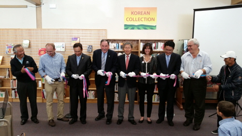Local Korean and American community leaders, including Salinas Mayor Joe Gunter, fourth from left, and San Francisco Korean Consul General Han Dong-man, to his right, held a ribbon-cutting ceremony Sunday inside John Steinbeck Library to celebrate the opening of the Korean collection.