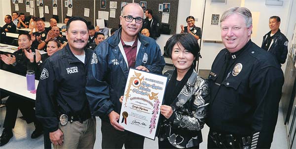 Laura Jeon, a KAFLA leader, second from right, presents a certificate of gratitude to LAPD Olympic Division Detective Sergio Martinez Wednesday. (Park Sang-hyuk/Korea Times)