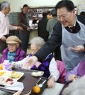 Yoo Dae-geun, president of the New York Korean American Supermarkets Association, helps hand out free Thanksgiving meals to seniors Wednesday.
