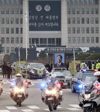 A vehicle putting up a portrait of the late former South Korean President Kim Young-sam leads a hearse after the state funeral for Kim at the National Assembly in Seoul, South Korea, Thursday, Nov. 26, 2015. Thousands of mourners gathered at the lawn outside parliament Thursday to say their farewells to Kim, whose landmark 1992 election victory ended decades of military rule and ushered in a series of reform measures. (AP Photo/Ahn Young-joon. Pool)
