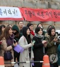 Fans of TVXQ's Chang-min and Super Junor's Si-won wait outside a Chungnam base Thursday morning to say goodbye before the two stars enlist in their 21-month military service. (Yonhap)