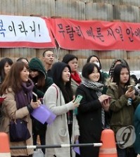 Fans of TVXQ's Chang-min and Super Junor's Si-won wait outside a Chungnam base Thursday morning to say goodbye before the two stars enlist in their 21-month military service. (Yonhap)