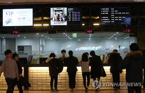 People purchase tickets inside a Seoul theater Monday. (Yonhap)