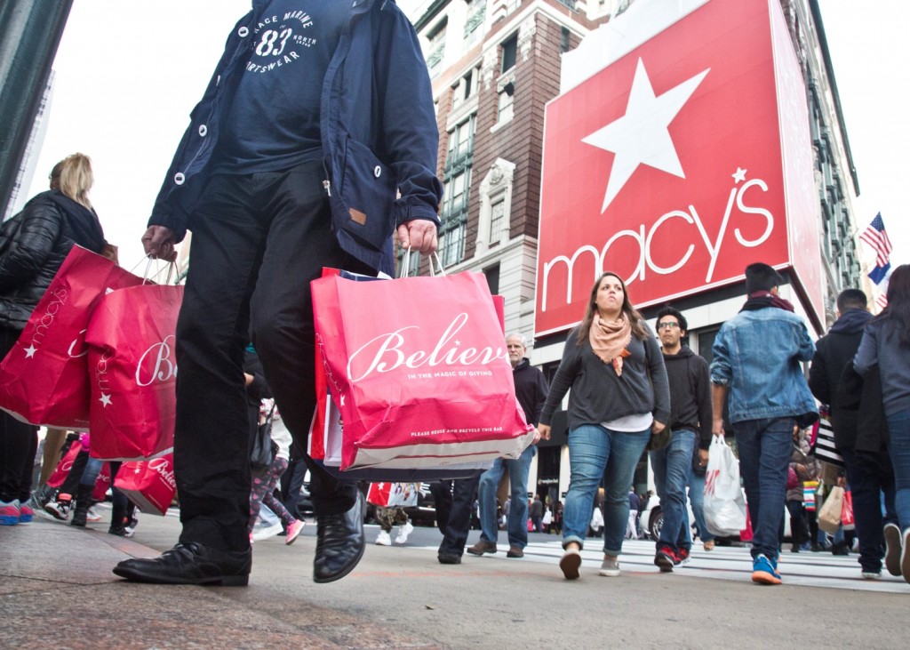 Shoppers carry bags as they cross a pedestrian walkway near Macy's in Herald Square, Friday, Nov. 27, 2015, in New York. The early numbers aren't available yet on how many shoppers headed out to stores on Thanksgiving, instead of waiting until today. But it's expected that more than three times the number who shopped yesterday will be out bargain-hunting today.(AP Photo/Bebeto Matthews)