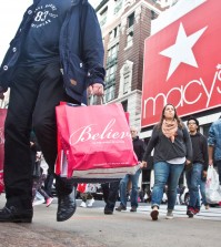 Shoppers carry bags as they cross a pedestrian walkway near Macy's in Herald Square, Friday, Nov. 27, 2015, in New York. The early numbers aren't available yet on how many shoppers headed out to stores on Thanksgiving, instead of waiting until today. But it's expected that more than three times the number who shopped yesterday will be out bargain-hunting today.(AP Photo/Bebeto Matthews)