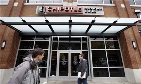 FILE - In this Nov. 9, 2015, file photo, pedestrians walk past a still-closed Chipotle restaurant in Seattle. An outbreak of E. coli that originated in the Pacific Northwest has spread south and east and has now infected people in six states. New cases have been reported in California, New York and Ohio, the Centers for Disease Control and Prevention said Friday, Nov. 20, 2015. (AP Photo/Elaine Thompson, File)