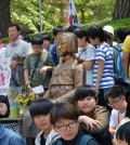 Japanese protesters stand around a comfort women memorial near the Japanese Embassy in Seoul. (Yonhap)