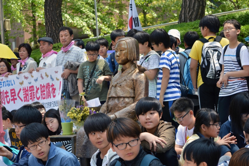 Japanese protesters stand around a comfort women memorial near the Japanese Embassy in Seoul. (Yonhap)