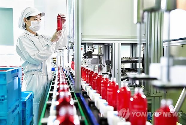 An employee at Amore Pacific, a South Korean cosmetic maker, examines a sample at a factory. (Yonhap)