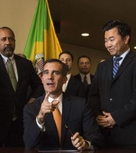 Los Angeles Mayor Eric Garcetti (sitting) speaks to reporters as Councilman David Ryu (right) listens. (Courtesy of David Ryu staff)
