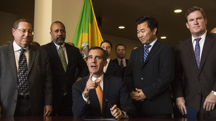 Los Angeles Mayor Eric Garcetti (sitting) speaks to reporters as Councilman David Ryu (right) listens. (Courtesy of David Ryu staff)