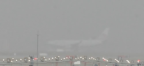 FILE -- Runway lights are lit at Incheon International Airport, west of Seoul, amid a cloud of yellow dust blowing from China on Feb. 23, 2015. (Yonhap)