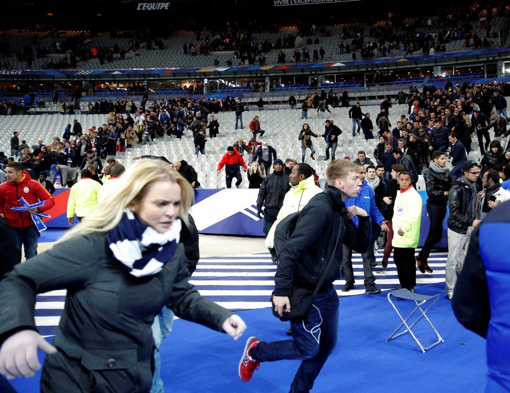 Spectators invade the pitch of the Stade de France stadium after the international friendly soccer match between France and Germany in Saint Denis, outside Paris, Friday, Nov. 13, 2015. Hundreds of people spilled onto the field of the Stade de France stadium after explosions were heard nearby during a friendly match between the French and German national soccer teams. French President Francois Hollande says he is closing the country's borders and declaring a state of emergency after several dozen people were killed in a series of unprecedented terrorist attacks. (AP Photo/Christophe Ena)