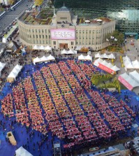 Kimchi makers form a heart shape at Seoul Plaza during the "Seoul Kimchi Festival" in 2014. (Courtesy of Seoul Metropolitan Government)