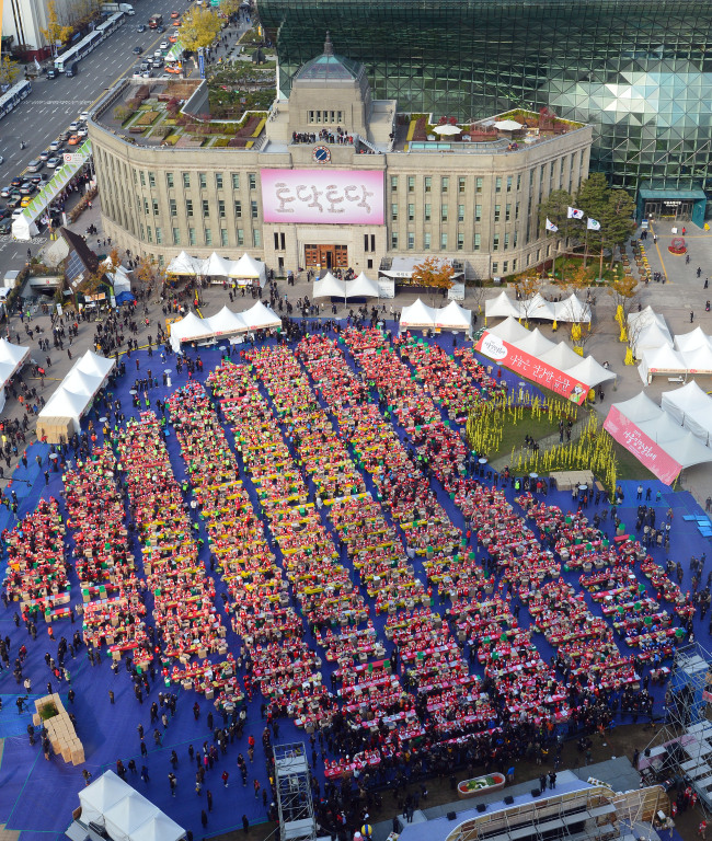 Kimchi makers form a heart shape at Seoul Plaza during the "Seoul Kimchi Festival" in 2014. (Courtesy of Seoul Metropolitan Government)